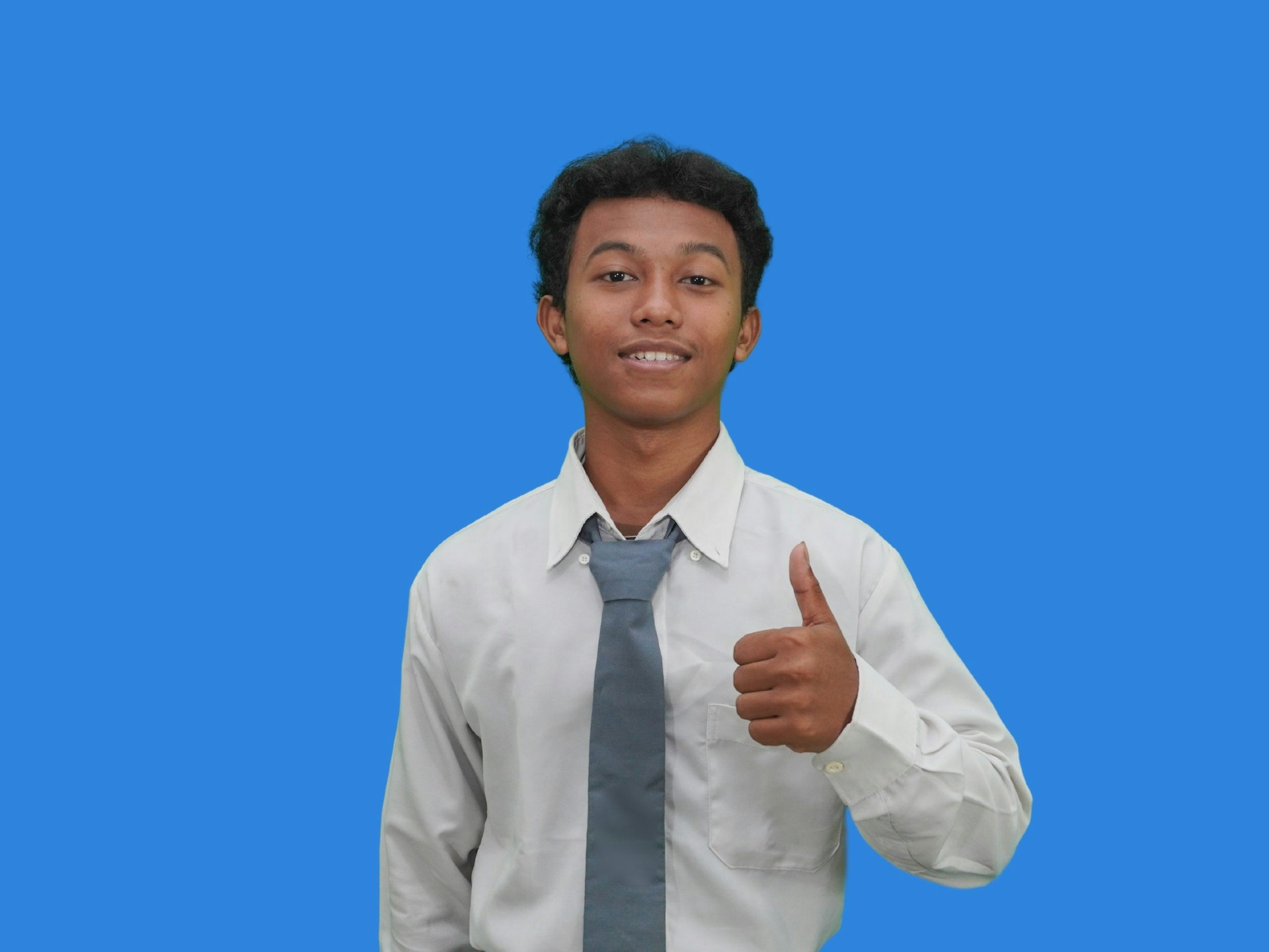 A man in a tie giving a thumbs up